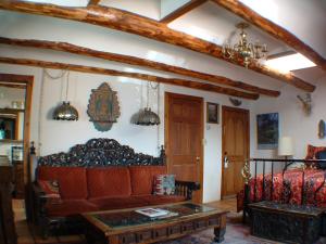 uma sala de estar com um sofá e uma mesa em La Dona Luz Inn an Historic B&B em Taos
