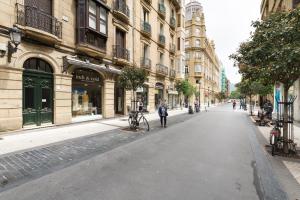 una calle urbana vacía con edificios y una persona parada en una bicicleta en Always Easy I Apata en San Sebastián