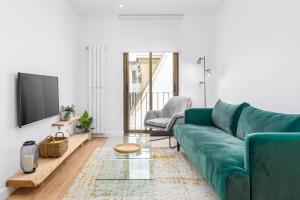 sala de estar con sofá verde y TV en Always Easy I Apata en San Sebastián