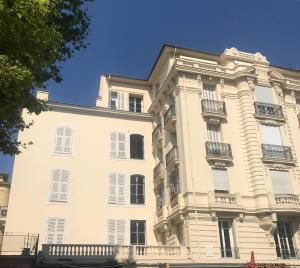 un grande edificio bianco con balconi di Nice Apartment Roses & Ivy, Rue du Congres a Nizza