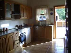 cocina con armarios de madera y horno de fogón blanco en Casa Rural cerca Es Trenc en Campos