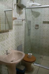 a bathroom with a sink and a shower at Pousada GaropaSul in Garopaba