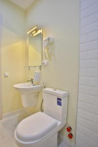 a bathroom with a white toilet and a sink at Chveni Qalaqi in Kutaisi