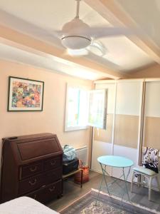 a bedroom with a bed and a table and a window at Villa de vacances au calme proche de la mer in La Londe-les-Maures +23 photos