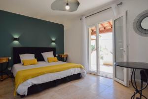 ein Schlafzimmer mit einem Bett mit einer grünen Wand in der Unterkunft Le Clos en Provence in Flayosc