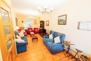 a living room with blue couches and a television at Casa Rural Laguna Negra 49 in San Leonardo de Yagüe