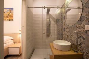 bagno con lavandino e doccia di Sammartino suite a Palermo