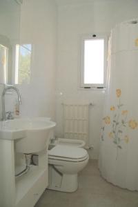 Baño blanco con aseo y lavamanos en Complejo Tridente en Pinamar