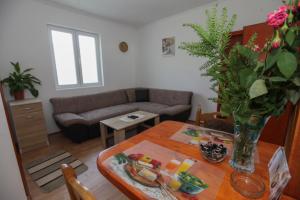 uma sala de estar com uma mesa e um sofá em Apartman Luka em Trebinje