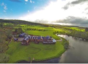 an aerial view of a large house on a lake at The Lodge on the Loch in Aboyne