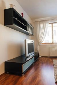 a living room with a tv on a black entertainment center at Nobless Apartment Brno in Brno