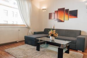 a living room with a couch and a table at Nobless Apartment Brno in Brno