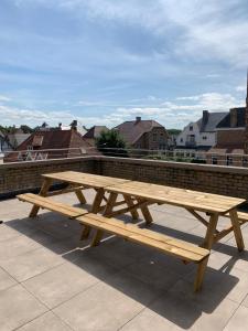 a wooden picnic table sitting on top of a roof at Le beau coin (belle-etage) in De Panne