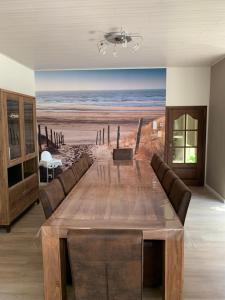a dining room with a table and a painting of the beach at Le beau coin (belle-etage) in De Panne