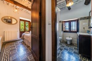 a room with a bathroom with a bed and a toilet at Casa Tita María in Bubión