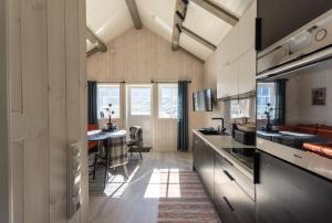 a kitchen with a counter and a dining room at Madelhea Cabin- Seaview Lodge in Reine