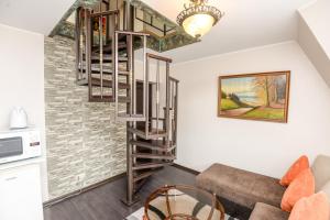 a spiral staircase in a living room with a couch at Columba Livia Guesthouse in Palanga