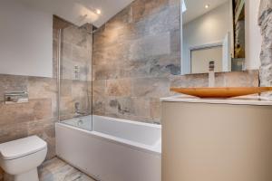 a bathroom with a tub and a toilet and a sink at Aysgarth Nook by Maison Parfaite - Luxury Holiday Home with Hot Tub in Aysgarth