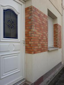 uma porta branca e uma parede de tijolos com uma janela em L'appart em Reims