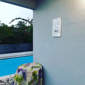 a room with a pool and a clock on the wall at La Villa Des Lys in Saint-Pierre