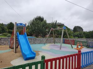 a playground with a blue slide and swings at VADOS - LA COLINA in Arnuero