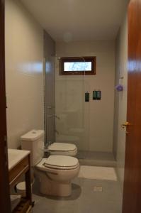 La salle de bains est pourvue de toilettes et d'une douche en verre. dans l'établissement La Chakana Humahuaca, à Humahuaca