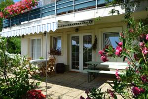a porch of a house with a bench and flowers at Anna Apartment in Budaörs