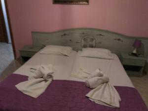 ein Schlafzimmer mit einem Bett mit Handtüchern darauf in der Unterkunft Amversa's Rooms in Skala Marion