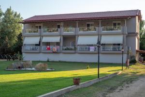 a large building with balconies on the side of it at Camping Linaraki Apartments & Bungalows in Sikia