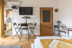 a kitchen and a living room with a table and chairs at Studio apartman Comodo in Zagreb