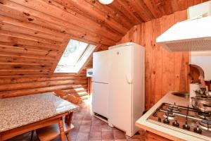 a kitchen with a white refrigerator and a stove at Vila Aura in Šventoji