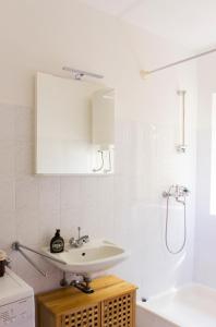 biała łazienka z umywalką i prysznicem w obiekcie Twin Oaks w mieście Šišan