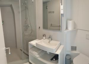 a white bathroom with a sink and a shower at Apartment Adriatico Eterno 2 in Rovinj +19 photos