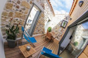 a balcony with blue chairs and tables on a building at La Charmeraie in Marseillan