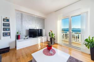 a living room with a tv and a large window at Apartments Mateljak in Gradac