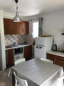 uma cozinha com uma mesa e um frigorífico branco em appartement les deux alpes em Les Deux Alpes
