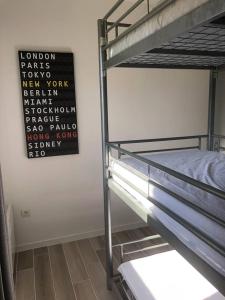 1 Schlafzimmer mit 2 Etagenbetten und einem Schild an der Wand in der Unterkunft Appartement T2 cabine dans résidence avec piscine proche Honfleur - Deauville - Pont L'evêque in Équemauville
