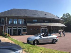 ein silbernes Auto, das vor einem Gebäude parkt in der Unterkunft Appartement T2 cabine dans résidence avec piscine proche Honfleur - Deauville - Pont L'evêque in Équemauville