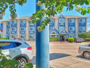 a blue building with cars parked in front of it at Arya Inn and Suites in Irving