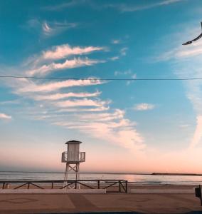 a lifeguard tower on the beach under a cloudy sky at ROOMQUEO-Only Adults in Barbate