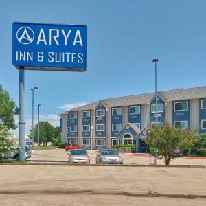 a sign for a inn and suites in a parking lot at Arya Inn and Suites in Irving