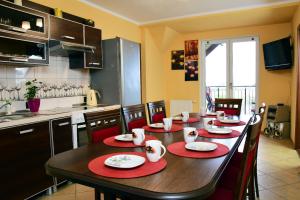 a kitchen with a table with red placemats on it at Ranczo u Stefana in Ustronie Morskie