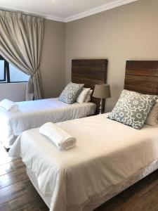 1 dormitorio con 2 camas y ventana en Ginger Barn, en Pretoria