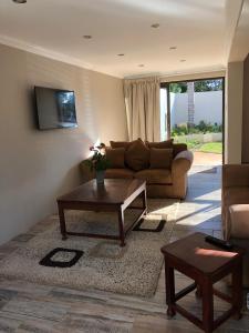 sala de estar con sofá y mesa de centro en Ginger Barn, en Pretoria