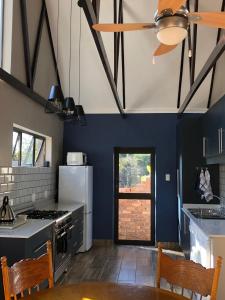 cocina con paredes azules y ventilador de techo en Ginger Barn, en Pretoria