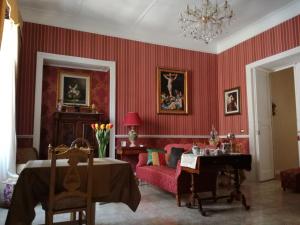 a living room with red walls and a table and chairs at La dimora del giurista in Rossano