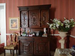 a large wooden cabinet in a room with a table at La dimora del giurista in Rossano +5 photos