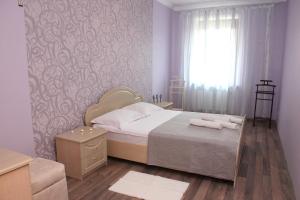 a bedroom with a bed with two towels on it at HISTORICAL OLD CITY Apartament, Старе місто , 2 спальні, балкон-тераса, 85 кв м in Kamianets-Podilskyi