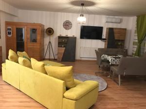 ハイドゥソボスローにあるDiamond houseのリビングルーム(黄色のソファ、テレビ付)