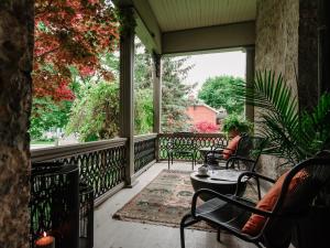 Eine Frau, die auf der Veranda eines Hauses sitzt. in der Unterkunft Rosemount Inn in Kingston